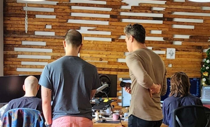 Two Moveck engineers reviewing results on screen with colleagues in the Quebec City office